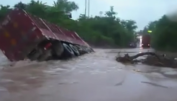 The truck driver bravely cross the river-like flow of water.