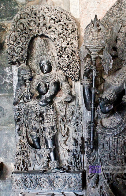 Female attendant behind the Dwarapalaka on the left side of the Hoysaleshwara shrine