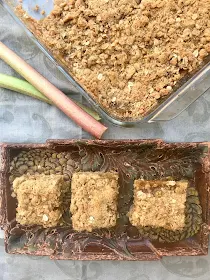Finished rhubarb oatmeal bars along with three cute squares on a plate.