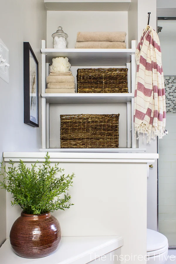 Bathroom open shelves next to toilet