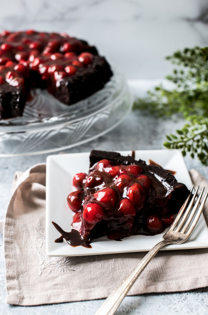 Sliced devils food cake topped with cherries