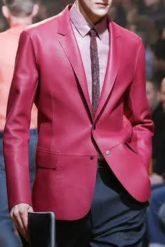 A model with face unseen wearing a pink leather blazer on the runway