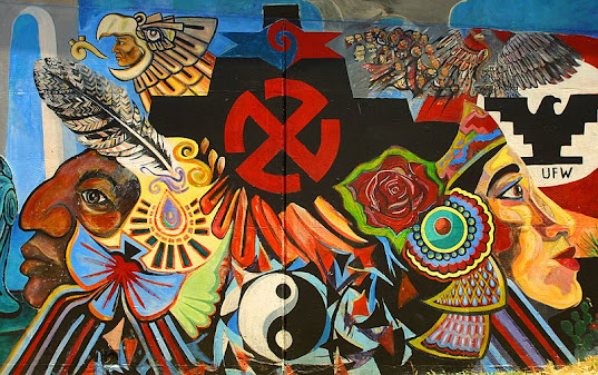 Chicano Park mural with Native American faces and large red swastika.