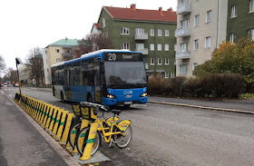 Linja 20 bussi, kerrostaloja taustalla.