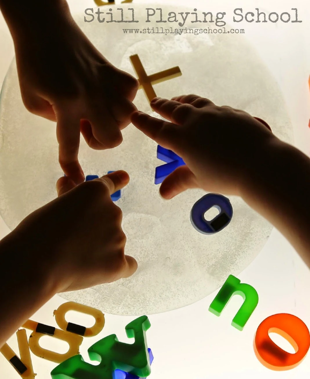 Stamping the alphabet in slime on light table from Still Playing School