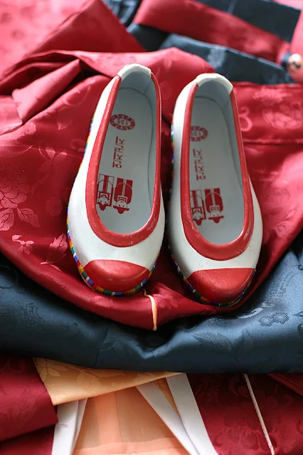 White-Rubber-Shoes-with-Red-Trims-on-a-Red-Hanbok-Photo-Credit-Wikimedia-Commons-HapaK