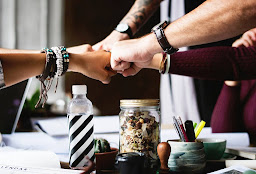 four peoples fists that are fist bumping in a harmonious way