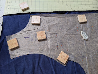 Pattern laid out on fabric with weights on pattern