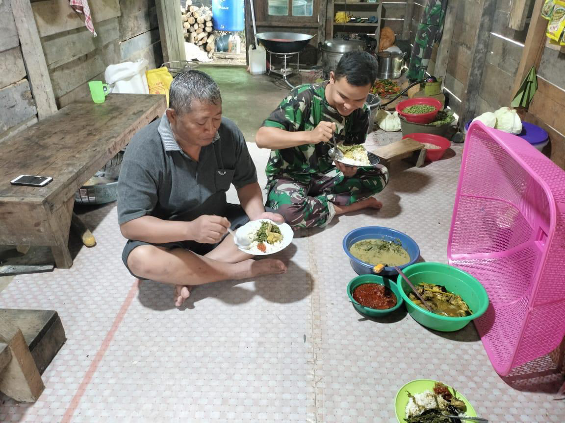 Anggota satgas TMMD makan bersama orang tua asuh di lokasi