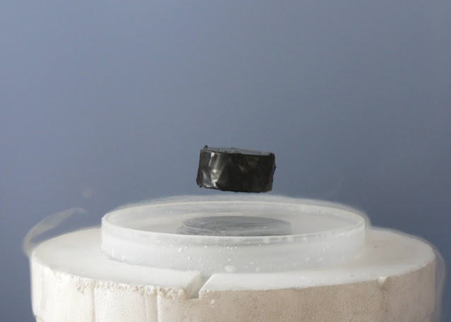 A magnet floats on a superconductor's disc