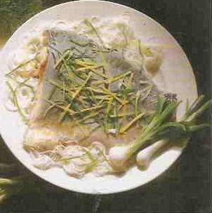 Karp gotowany na białym talerzu, z makaronem chinski i szczypiorkiem