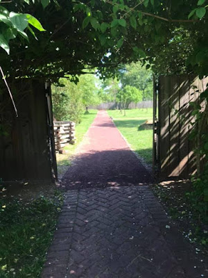 Brick walking path shaded by trees at Pennsbury Manor