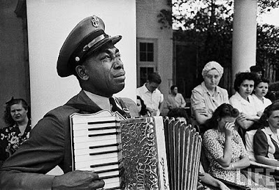 Navy CPO Graham Jackson as he Plays 'Goin' Home' on the accordion while President Franklin D. Roosevelt's body is carried from The Warm Springs Foundation, where he died suddenly of a stroke on April12, 1945