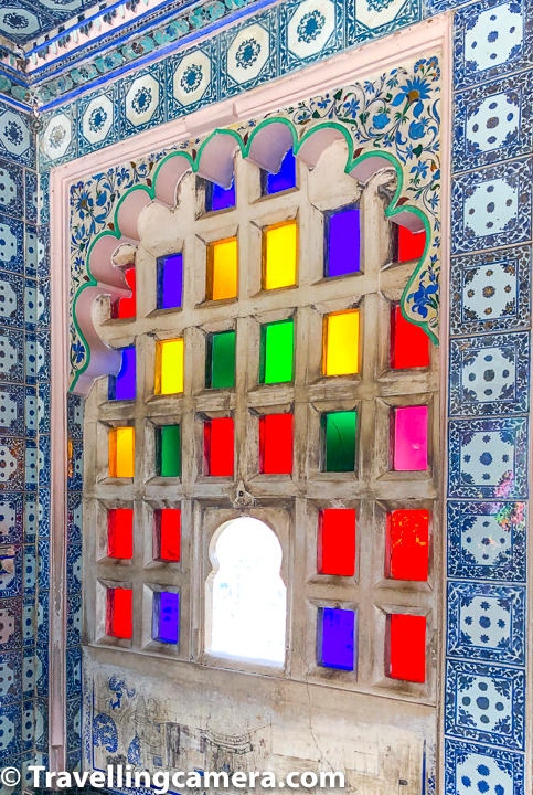 Above photograph shows one of the jharokhas with small space to take out your neck and look outside. Rest of the window is filled with colourful glassed and a frame of cement. While I was in this part of Udaipur City Palace, I was wondering when these blue tiles were added to the palace. They can certainly be old because this kind of work for kitchenware was available, but I forgot to confirm with our guide.