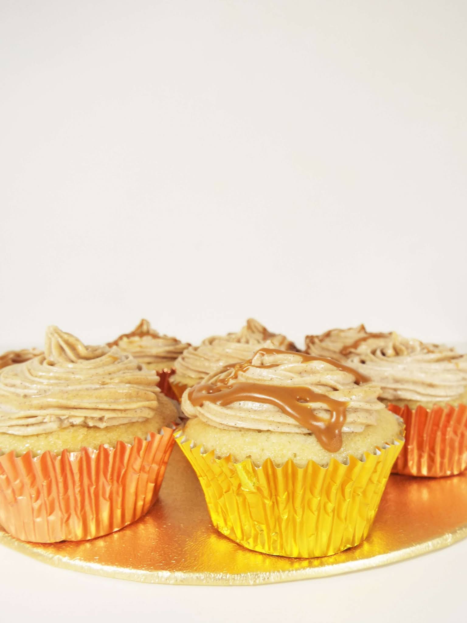 Close up shot of the cinnamon spiced biscoff cupcakes, iced and alternatively drizzled in biscoff spread.