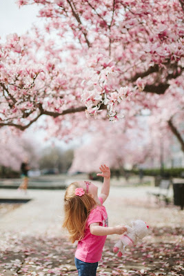 Child playing confidently under a tree.