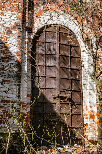Массивная высокая металлическая дверь церкви
