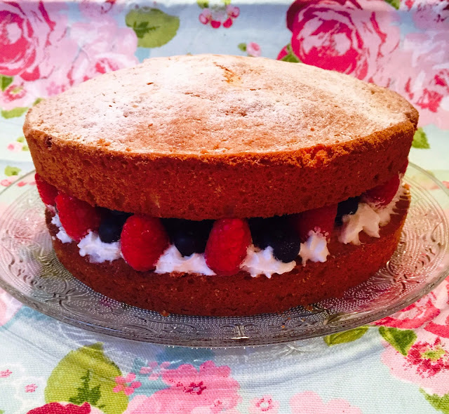 Classic Victoria sandwich cake with fresh raspberries, blueberries and cream