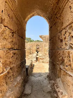 looking through a roman arch onto the ruins of carthage, tunisia