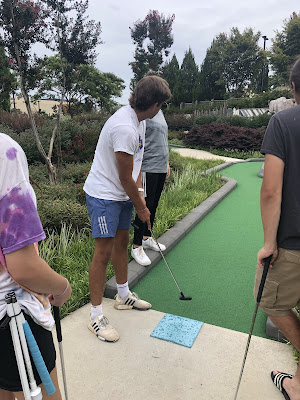 Josh taking his turn at a tee on the golf course.