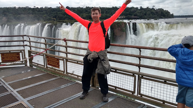 bright orange standing in front of Iguazu's Deil's Throat