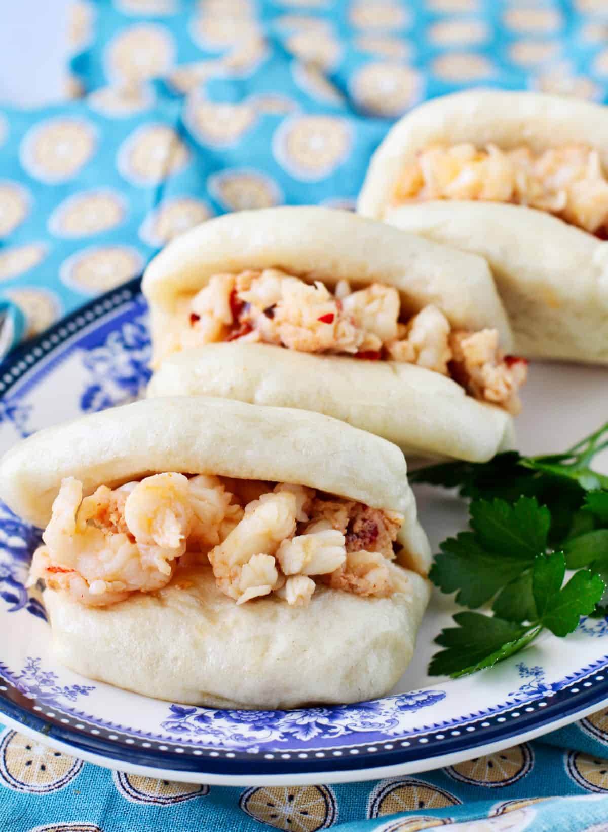 Spicy Lobster Bao lined up on a plate.