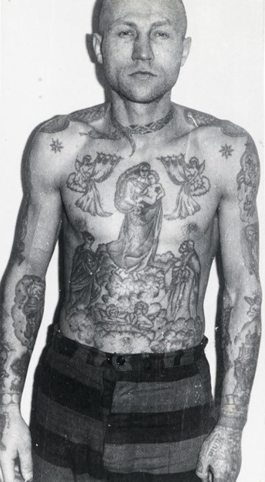 A snake around the neck is a sign of drug addiction. The stars on the clavicles and epaulettes on the shoulders show that this inmate is a criminal authority. The Madonna and child is one of the most popular tattoos worn by criminals — there can be a number of meanings. It can symbolise loyalty to a criminal clan; it can mean the wearer believes the Mother of God will ward off evil; or it can indicate the wearer has been behind bars from an early age.