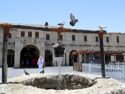 Pigeons linger around a fountain at Qatar's touristic Souq Waqif bazar in the capital Doha