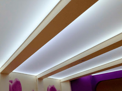 Красивый натяжной потолок с необычным освещением и балками фото