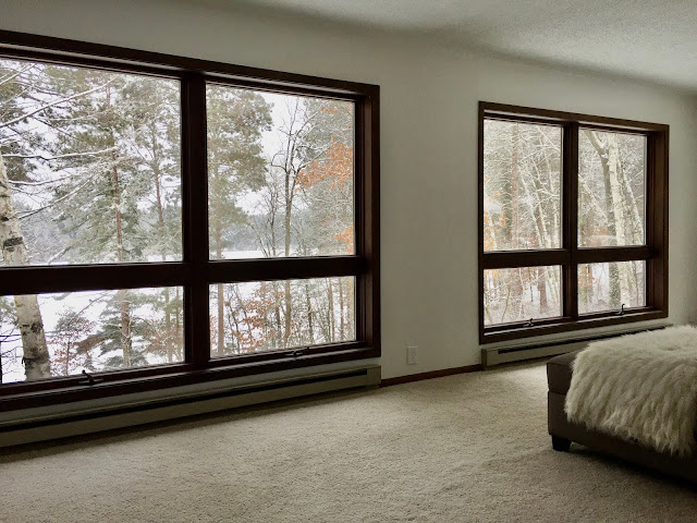 mountain style cabin home living room with floor to ceiling windows viewing the lake