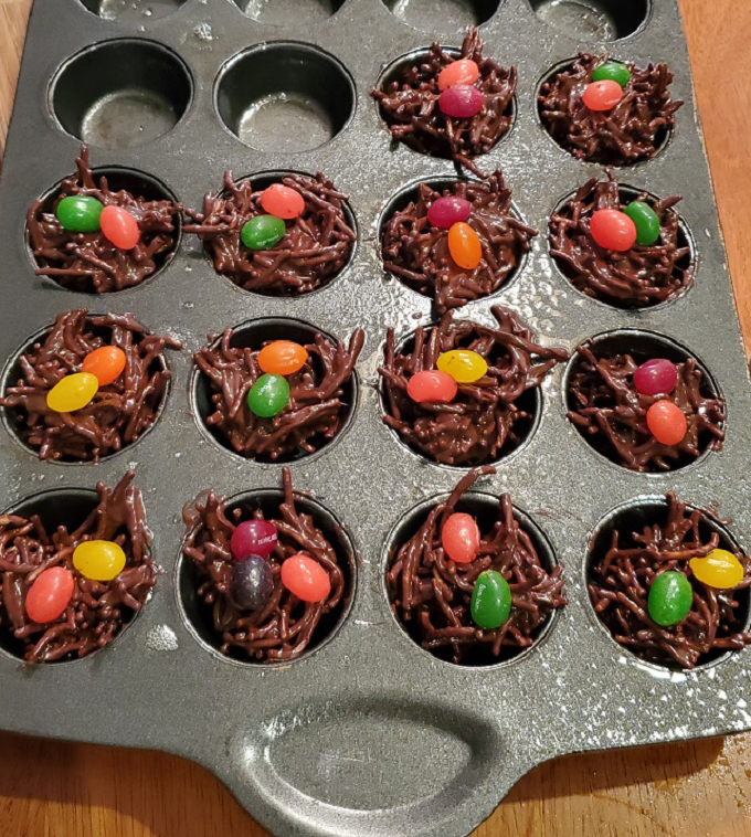 these are nests made out of melted chocolate, Asian fried noodles and topped with jelly beans in a mini muffin pan