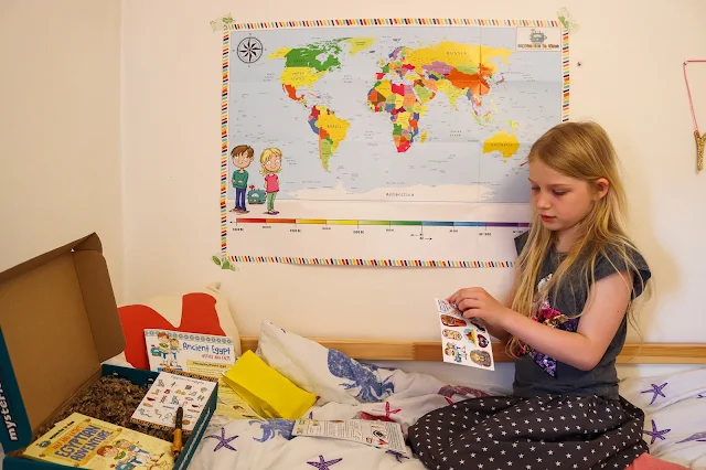 A girl investigating the Mysteries in Time subscription box she received to review