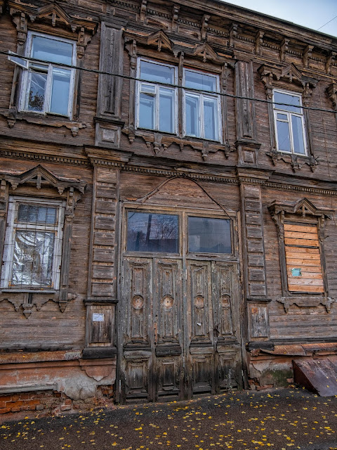 Широкие, резные двери у деревянного дома