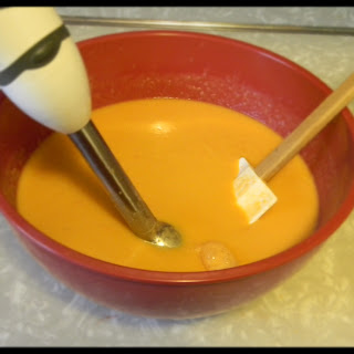 Blending while scraping the bowl to get a smooth consistency.