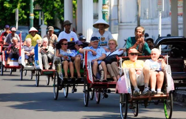 Wisatawan Jalan-Jalan Mengelilingi Kota Menggunakan Becak