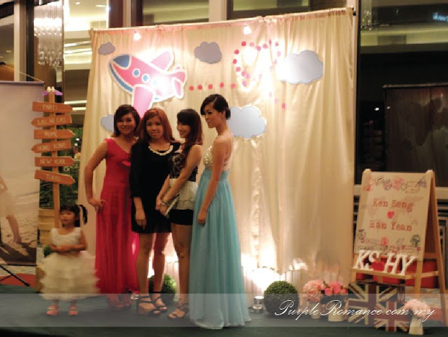 Photo Booth Backdrop Decoration, wooden signage with country names, green carpet, green grass balls, wedding poster, welcome board with country passport stamps, initial, london bags, white fences, aeroplane, cute, clouds, Kuala lumpur, mandarin oriental hotel, selangor