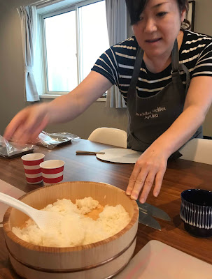 Sushi chef Ayulo Akivama points to a bowl of rice