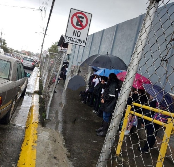 En Escuela José Cubero Muñoz: Estudiantes hacen fila bajo la lluvia
