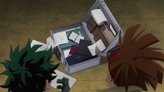 Izuku and Rody looking at an open suitcase, the files and papers inside strewn about.