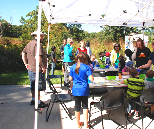 Families engaging in art experiences in the stunning nature of Crabtree Nature Center during Art in Nature. Image credit Artistic Journeys.