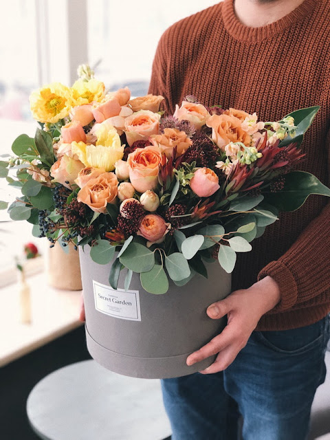 A person carrying a pail full of roses.