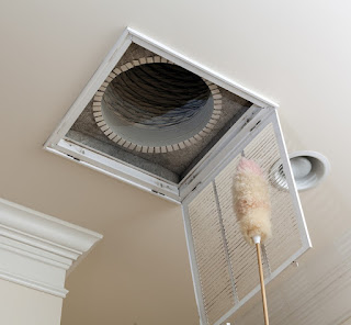 A person dusting an air vent
