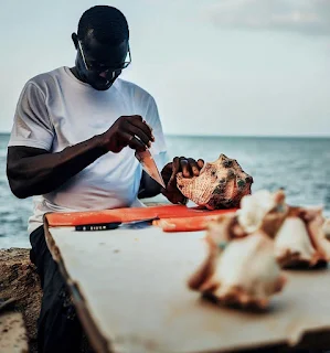 Cutting up conch by the sea