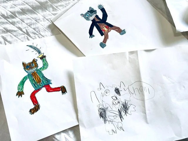 3 pieces of white paper with 3 different cartoon pirate wolves drawn on them