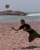 Peter diving for a pass playing some beach football with their rugby ball.