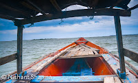 Chilika lake is one of the popular places to visit in Odisha  and it’s spread over Puri, Khurda and Ganjam regions of Odisha state. It’s on east coast of India which flows into the Bay of Bengal. It’s largest coastal lagoon in India and second largest lagoon in the world. The largest one is New Caledonian barrier reef. Recently we visited Chilika lake and this Photo Journey shares some of the photographs telling story of our visit.Supposedly Chilika Lake is largest wetland on the Indian sub-continent for Migratory birds in winters. Lot of tourists visit Chilika lake but main ecosystem is around fishery resources. There are thousands of fisher-folks in villages around shoreline and islands around Chilika Lake.How to reach – Most of the folks visit Chilika Lake from Bhubaneshwar or Puri. Taxi is one of the best ways to save time and explore the beauty on your way. Balugaon is nearest railway station and then auto can help you reach near Chilika lake. In the world of Ola and Uber, commute has become easier and convenient. One doesn’t need to negotiate with unreasonable cabbies and auto-walas outside Railway-station or bus-stand. I am sure, buses from main cities would be available but. There are different views of people visiting Chilika. Nature lovers would certainly love the place and if you like following birds, it's certainly a good place for you.As you see lot of these pearls being shown in our photographs. So this is a typical thing in Chilika lake that locals show you pearls and different kinds of stones. And they break shells in front of you. Not sure how real these are but we bought few by paying few thousands. There are lot of stories about the stones sold around Chilika. For a moment, we were also depressed by the thought that stone we bought can be fake. We are not experts and we don't even want to get these tested (for our own peace). But be cautious before taking such decision. They can be fake or real. You have to see if you like any of these stones and willing to pay a price.Boat rides are interesting but they don't give life jackets which was surprising for us. We didn't see dolphins in Chilika lake. It seems that early morning view around Chilika lake is very interesting.Since lake is huge, boating experience of Chilika Lake is different.