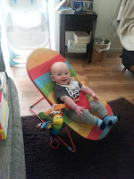 A baby sitting in a bouncy chair