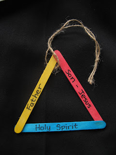A triangle made of coloured lolly sticks. They have Father', 'Son - Jesus', and 'Holy Spirit' written on them.