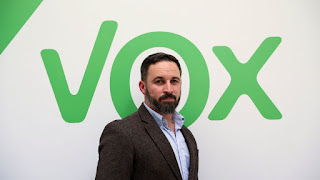 Santiago abascal frente a una imagen icónica de su partido "vox"