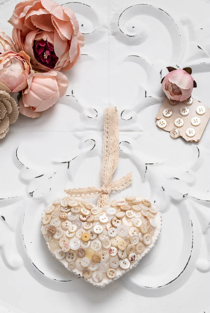 creamy white button heart hanging, pink peonies, vintage buttons